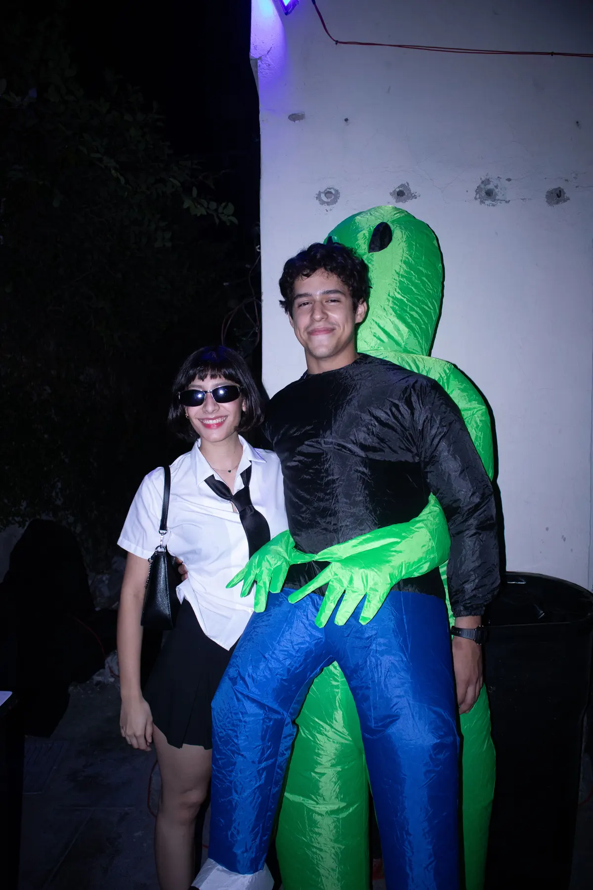 una invitada de uniforme y otro abrazado por un disfraz de extraterrestre