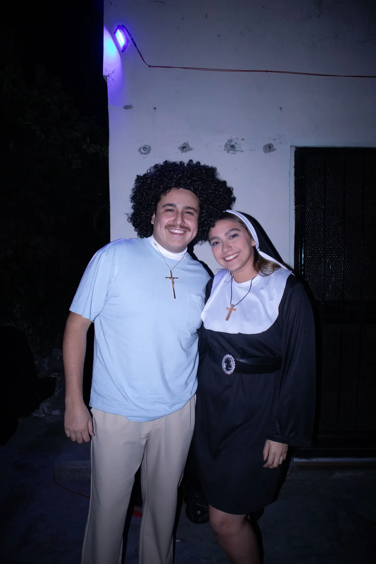una pareja disfrazada, él con afro y ella de monja