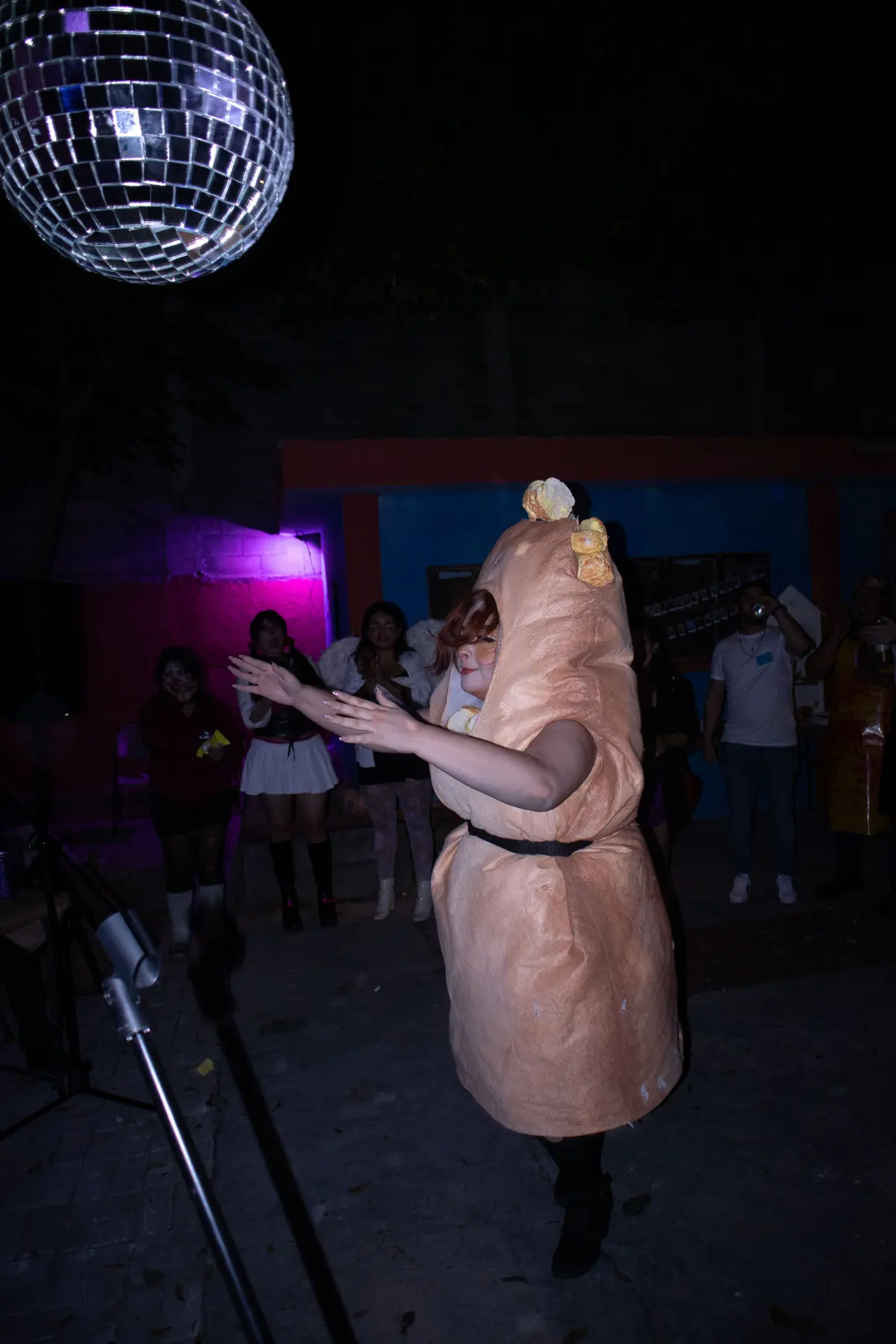 alguien disfrazado de pan bailando bajo la bola disco