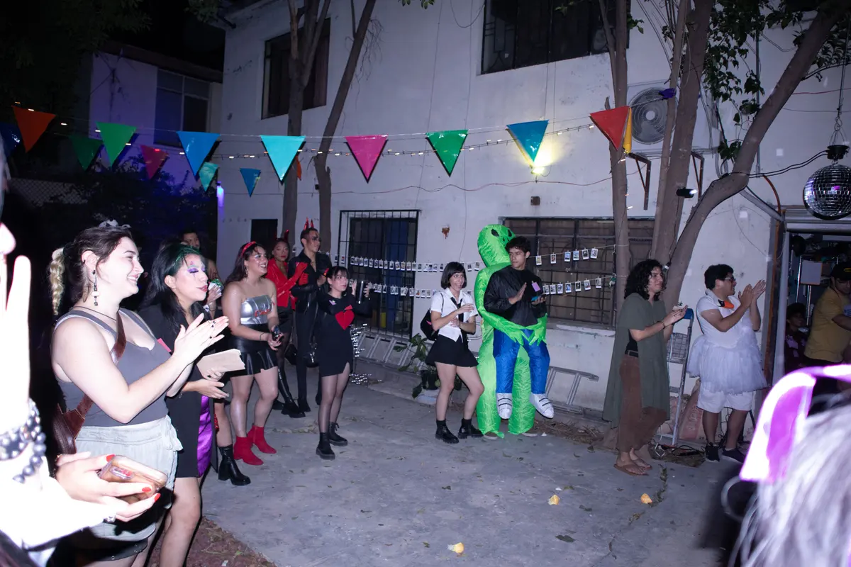 el patio con banderitas y los invitados disfrazados