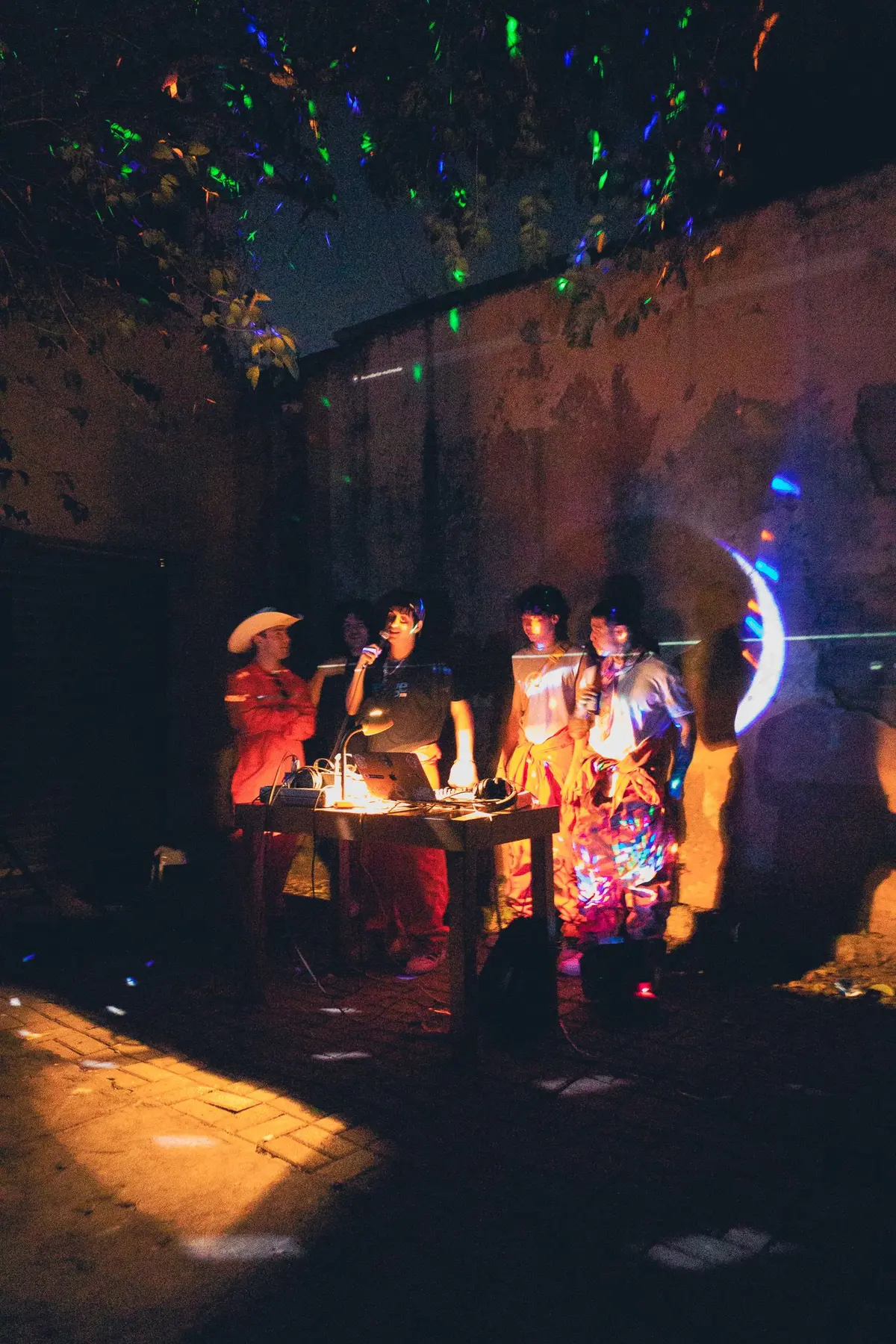 la mesa de los djs con velas, al fondo del patio