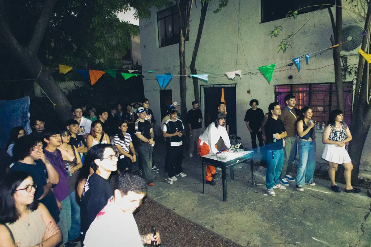 el público alrededor de la mesa, todavía de día
