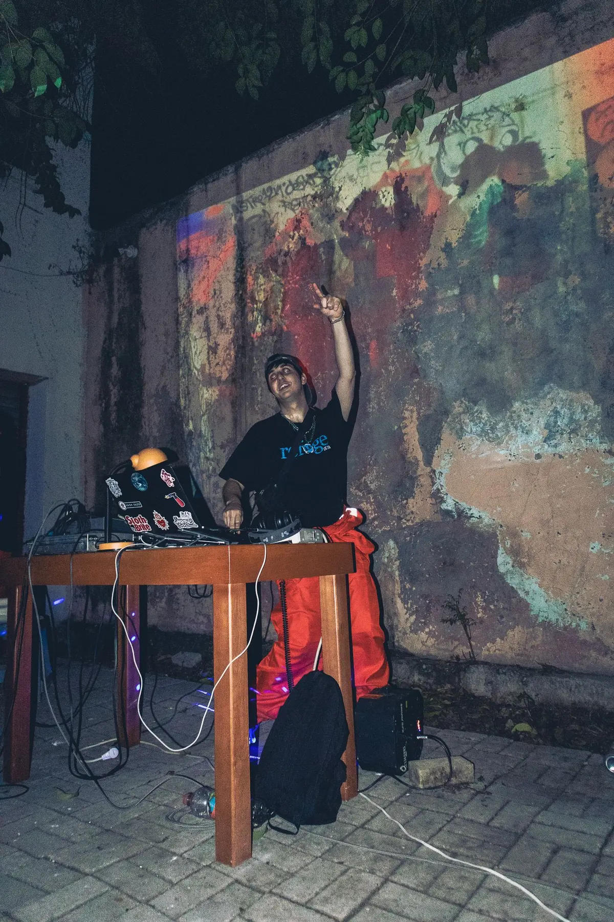 el dj con el brazo arriba frente al muro