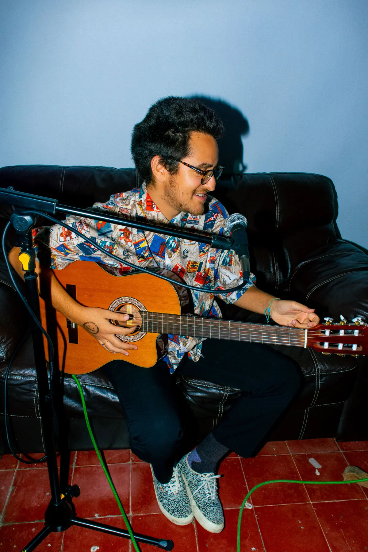 un músico tocando la guitarra en el sillón
