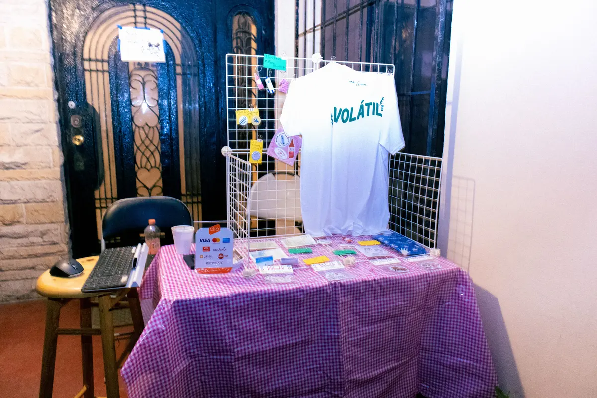 la mesa de playeras y stickers junto a la puerta