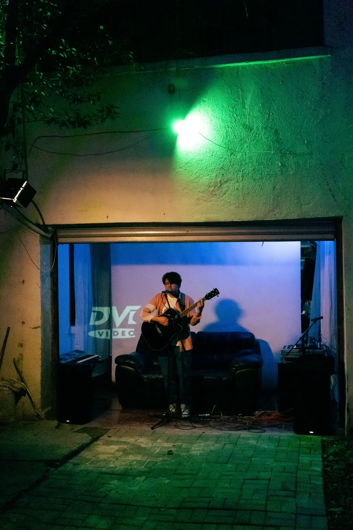 el patio verde y, al fondo, el escenario en la cochera