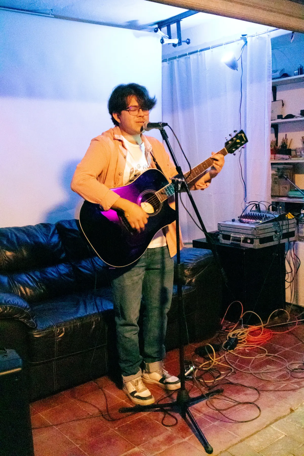 un cantante con guitarra frente al sillón