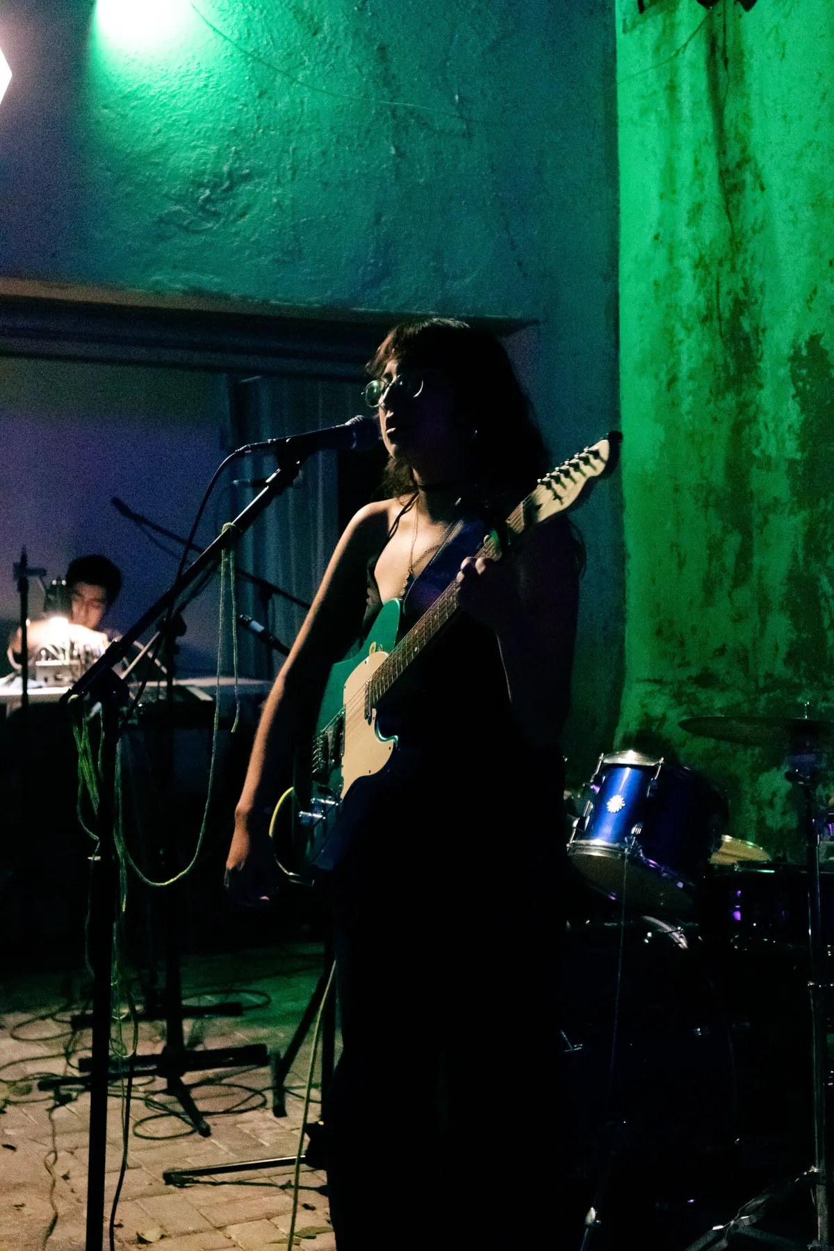 una cantante con guitarra, en luz verde