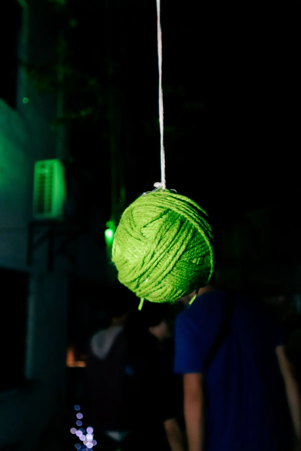 una bola de estambre verde colgando sobre el público