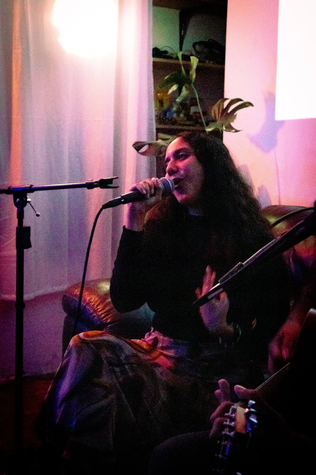 valeria jasso cantando en el sillón, con luz rosa